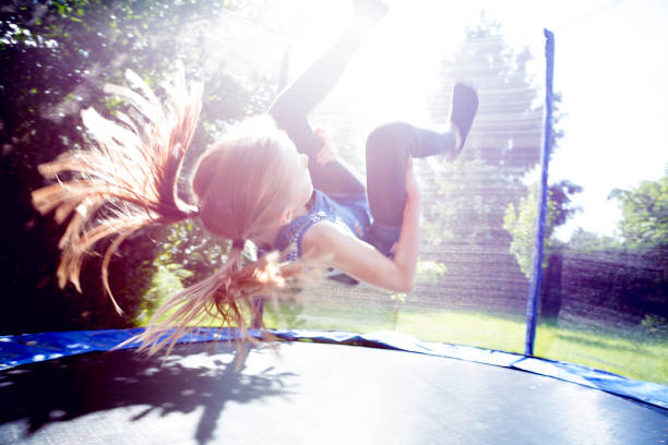 Petite fille qui fait un salto arrière dans un trampoline