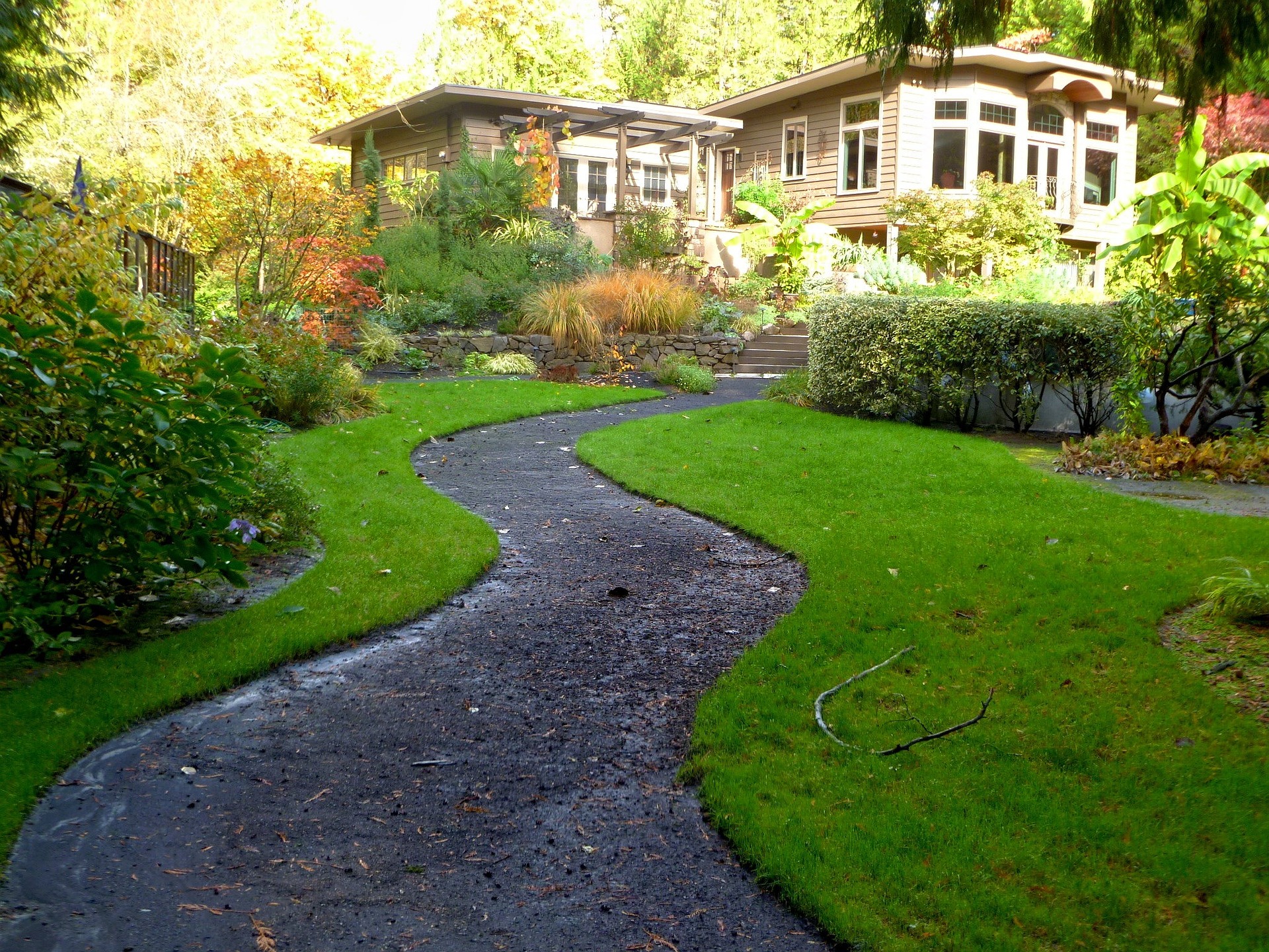 Maison avec grand jardin aménagé et bien entretenu parcouru par un petit chemin